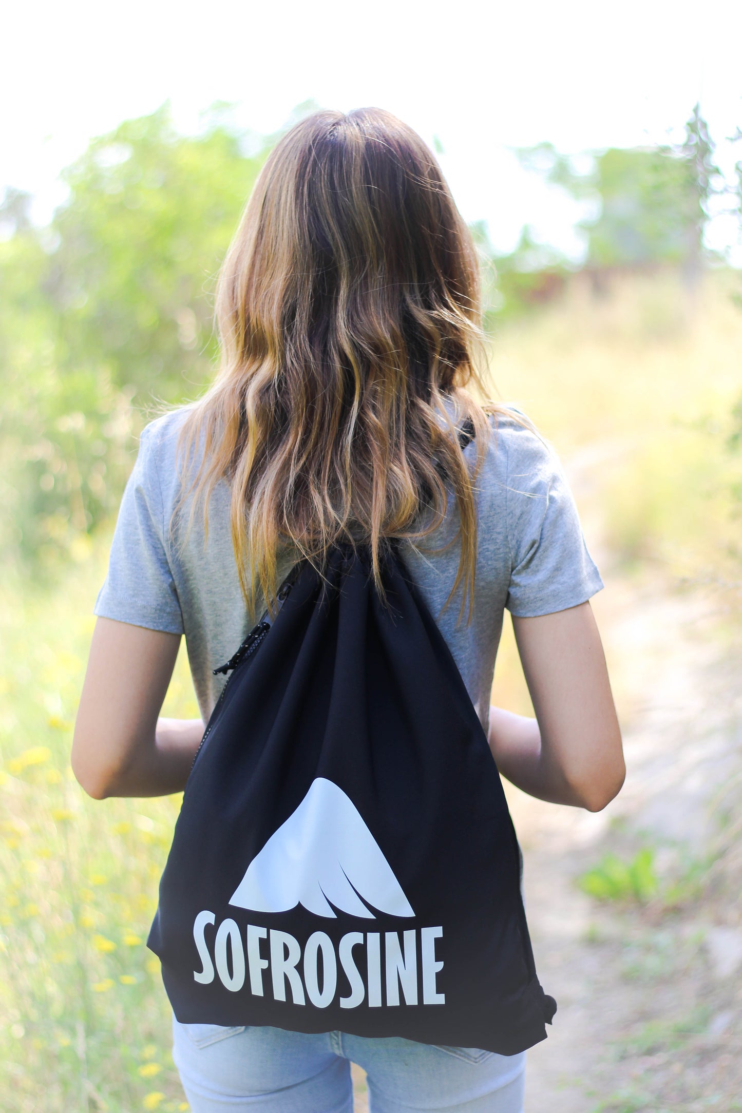 chica de pelo rubio luce mochila de cuerdas sofrosine