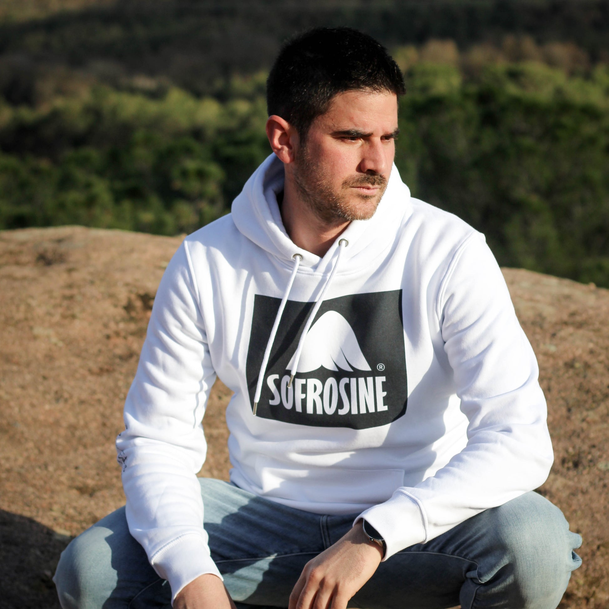 chico joven agachado con sudadera sofrosine