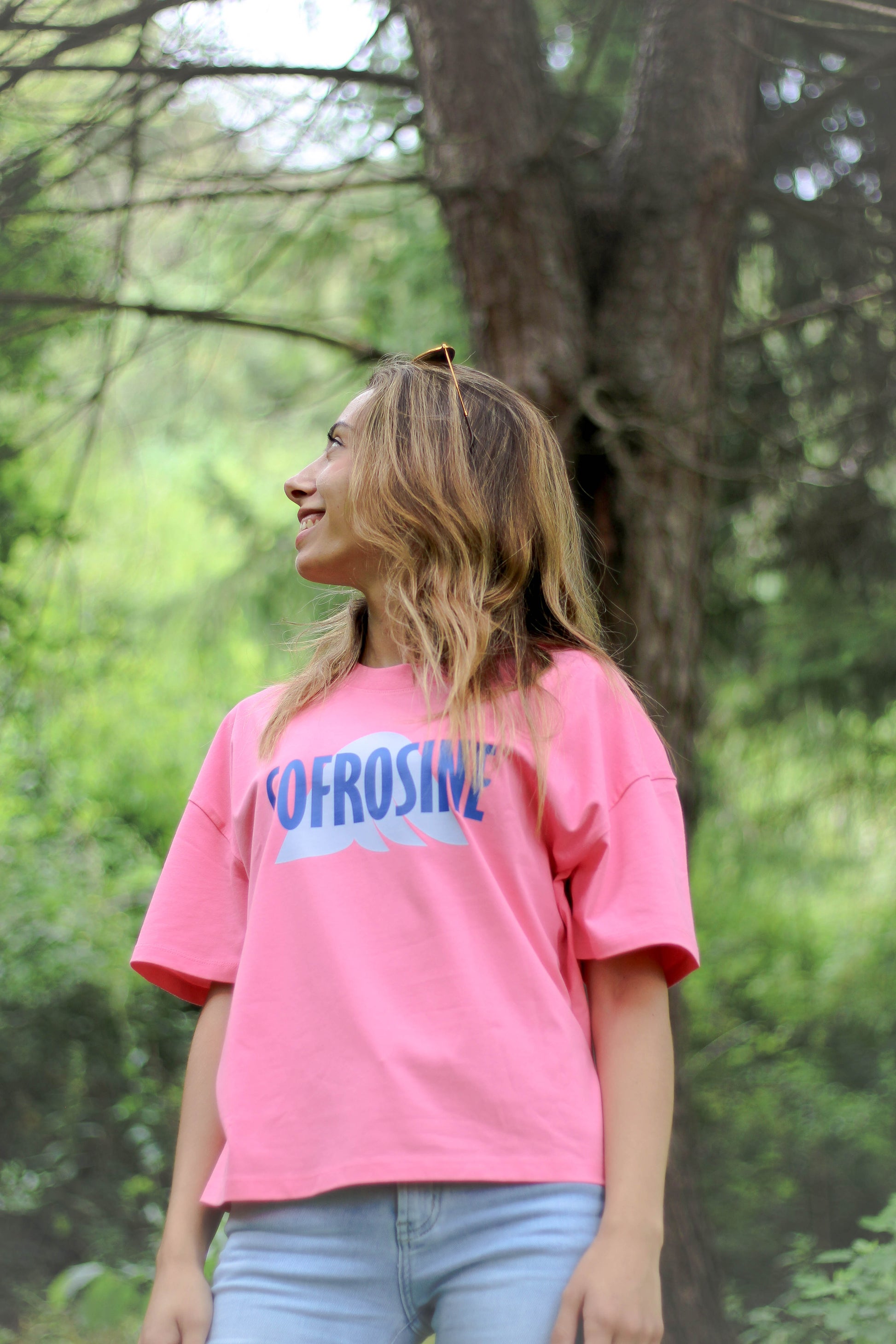 chica de perfil sonriente con camiseta rosa oversize marca sofrosine