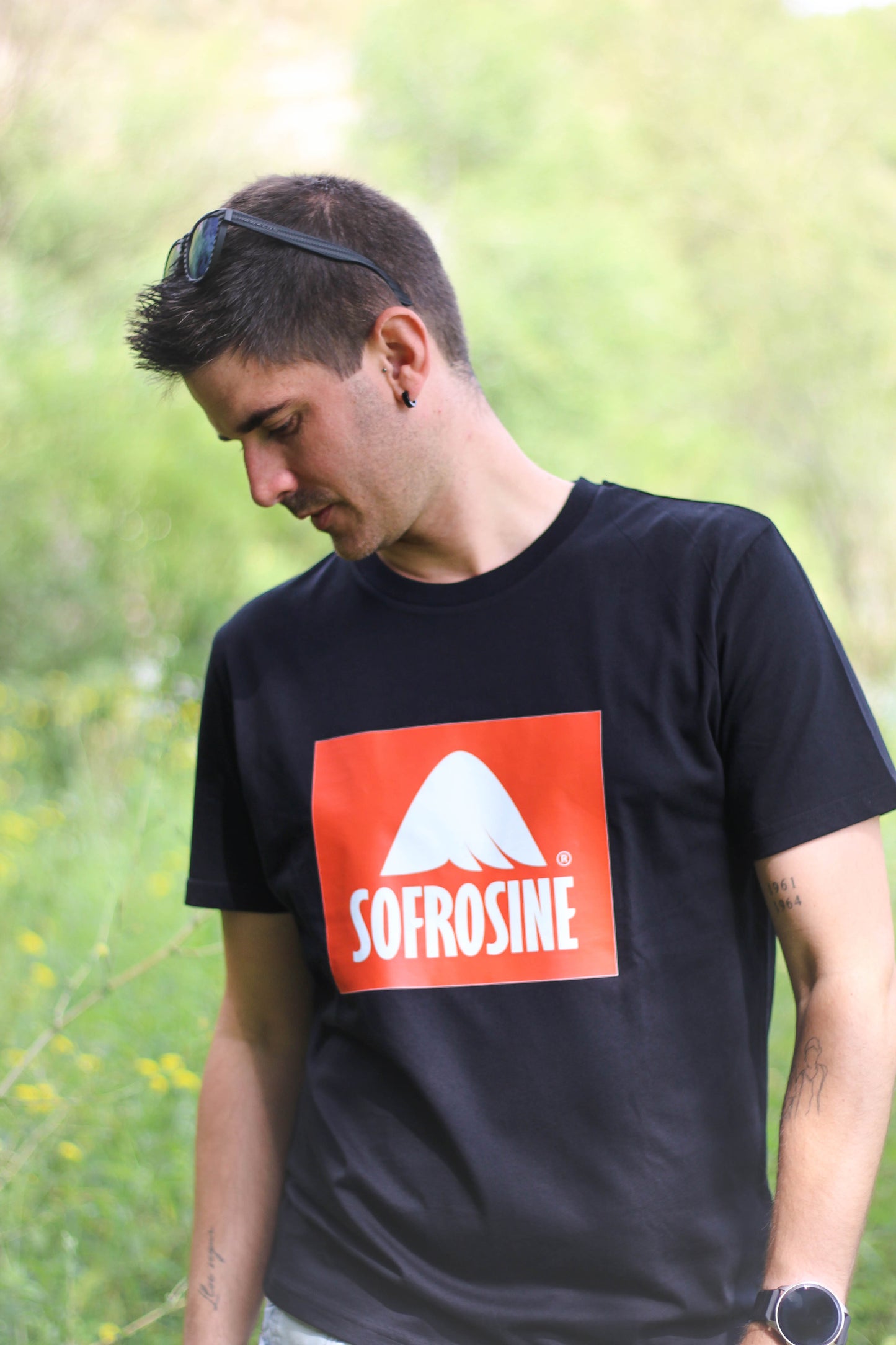 chico mirando hacia el suelo con camiseta negra sofrosine logo en caja