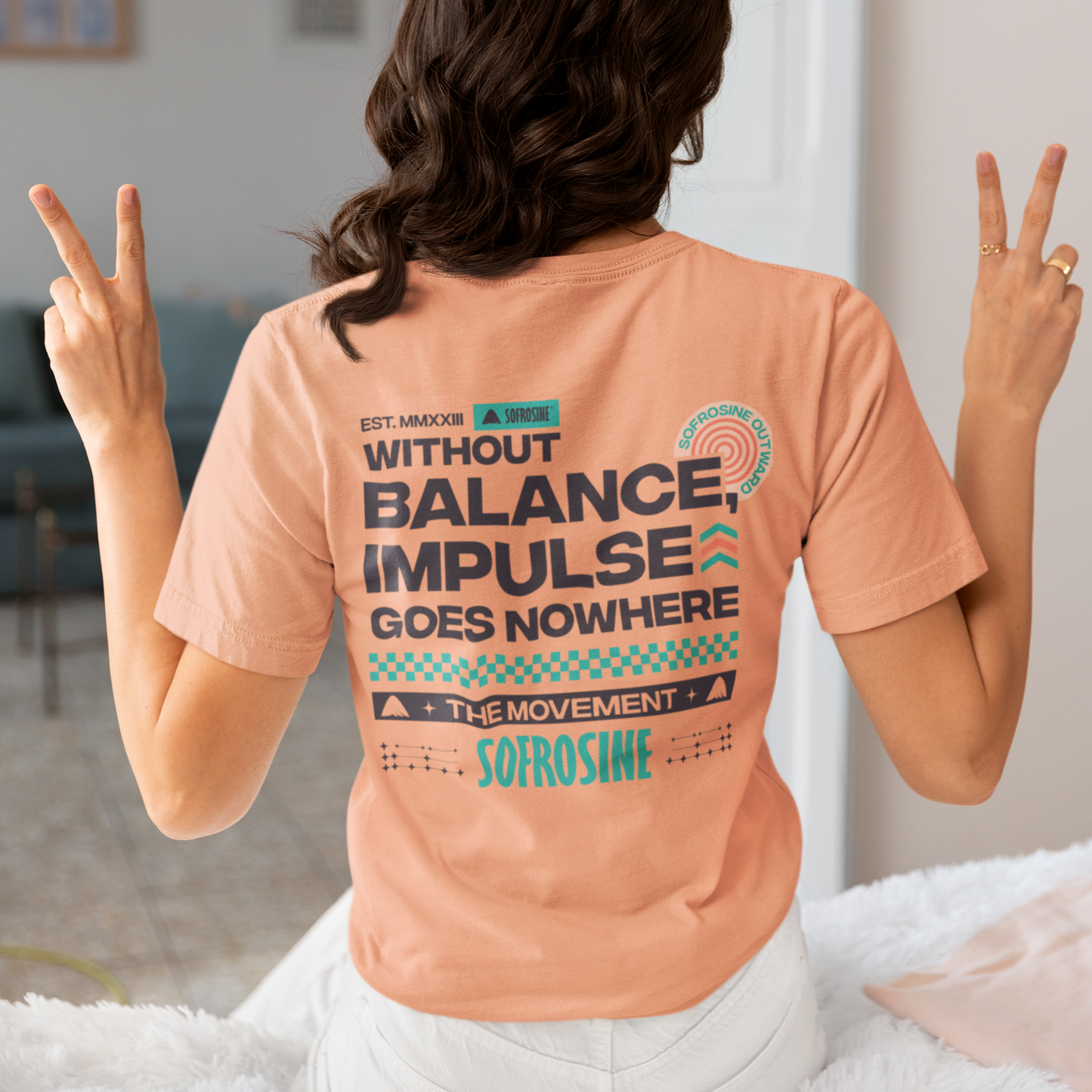 chica sentada de espalda con la camiseta balance impulse sofrosine apricot